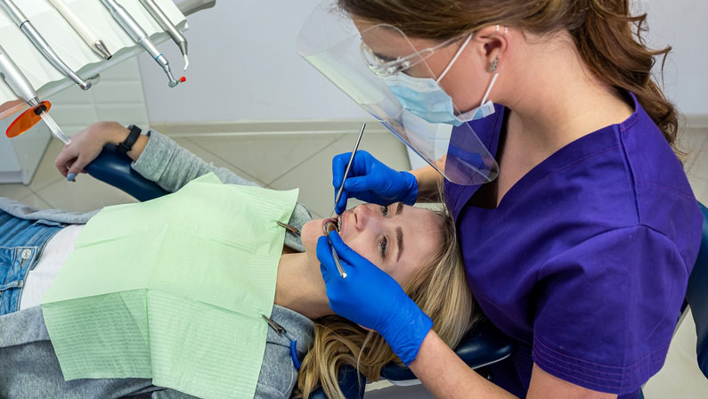 in a specialized dental clinic, a female dentist receives clients with problem teeth. Dental treatment concept