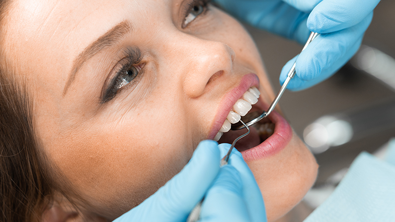 In the dental office, the doctor confidently works with modern equipment and tools, providing the patient with effective and painless dental care. Close-up of the patient's teeth