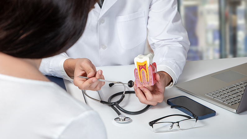 Doctor consulting a female patient about dental diseases in the office.