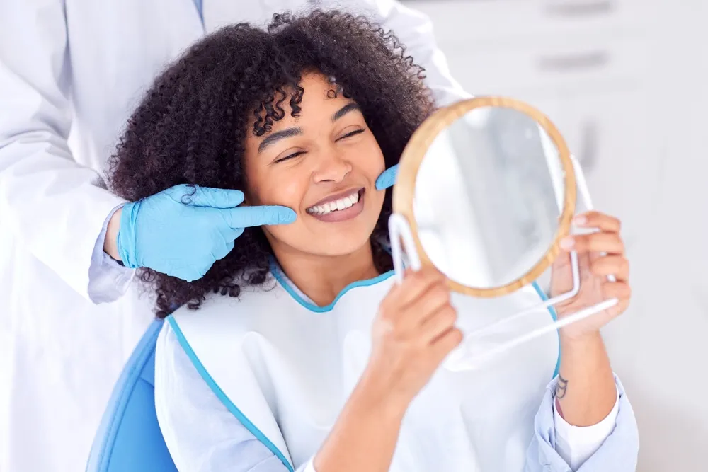 Woman, patient and dentist with mirror for teeth whitening in clinic for dental surgery and results with doctor